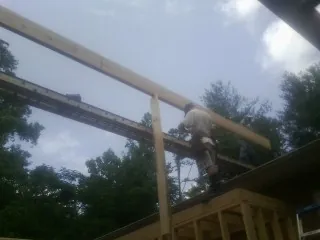 Carpenter setting a ridge beam over a new addition frame — Ice Dam Removal by Roofing Brothers in Jerome