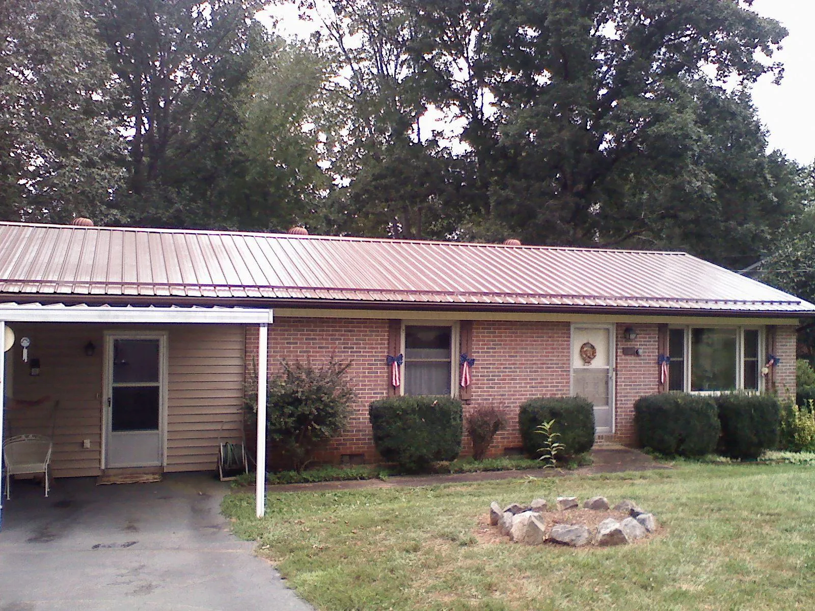 Bronze metal roof and carport on a brick ranch home — Roof Repair work by our crew in Jerome